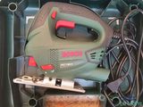 a green box with a black and red electric tool inside of it
