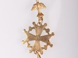 an image of a gold cross with a bird on it