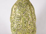 a yellow and black vase on wheels on a white surface