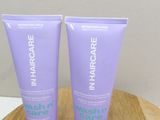 two tubes of hair care sitting on top of a wooden table