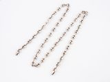 three pieces of silver chain on a white surface