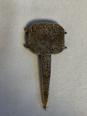 a close up of a small metal object on a white surface