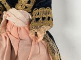 an antique doll of a woman in a black and gold dress