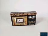 a game and watch gold box on a white surface