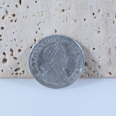 une pièce d'argent posée sur un morceau de bois