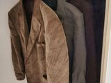 three coats hanging on a rack in a closet