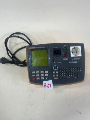une calculatrice posée sur une table, avec une étiquette de prix accrochée dessus