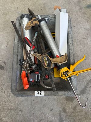de nombreux outils qui traînent dans une boîte posée par terre