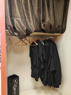an image of a closet with clothes on hangers
