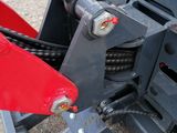 a close up of a red skid steer on the back of a tractor