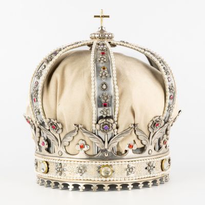 une vieille couronne surmontée d'une croix, posée sur un fond blanc