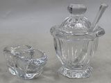 un bocal en verre avec une cuillère et un saladier en verre contenant une cuillère