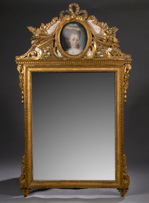 un miroir ancien dans un cadre doré, représentant le portrait d'une femme