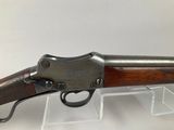 a rifle with a wooden barrel and a metal handle