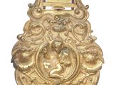 a gold clock with a birdcage on top of it