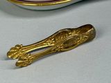a gold spoon sitting next to a cup and saucer