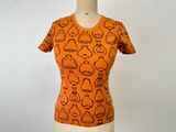 un t-shirt orange orné d'un motif représentant des théières et encore des théières
