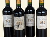 quatre bouteilles de vin sont alignées sur une surface blanche