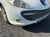 une voiture blanche garée dans un parking à côté d'un bâtiment