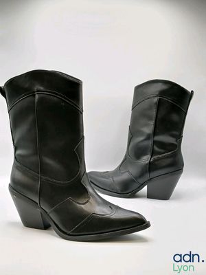une paire de bottes de cow-boy en cuir noir sur fond blanc