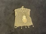 a close up of a gold purse on a black surface