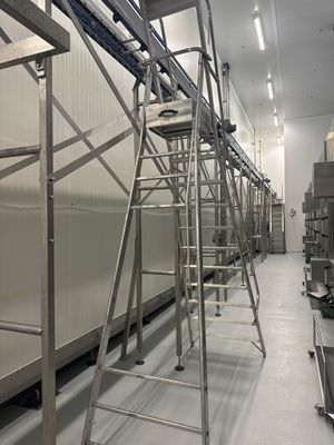 une photo d'une usine avec de nombreuses étagères et échelles
