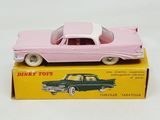 pink toy car sitting on top of a box on a white surface