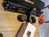 une table sur laquelle se trouvent un ordinateur portable, un appareil photo et d'autres appareils électroniques