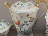 many plates and cups and a teapot on the table