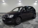 la voiture noire est garée sur un sol en damier dans le garage
