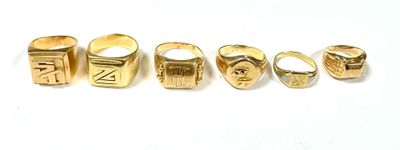 five different types of gold rings on a white surface