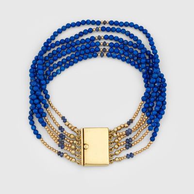 un gros plan sur un bracelet composé de perles bleues et doté d'un fermoir doré