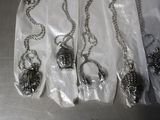 a lot of silver necklaces that are on a table