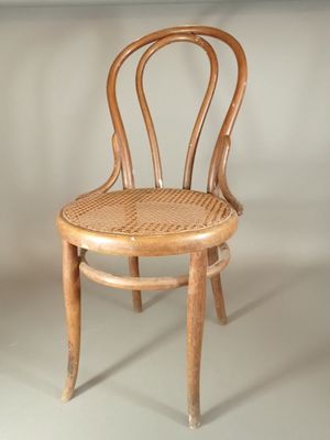 a wooden chair with a wicker seat on a white background