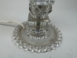 a glass candle holder with a candle on top of it