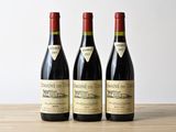 trois bouteilles de vin posées sur une table en bois