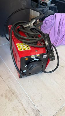 une personne allongée par terre à côté d'une machine rouge et noire