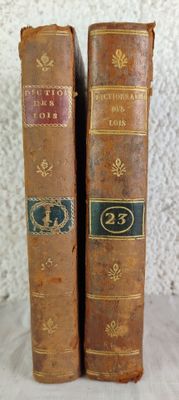 Deux vieux livres sont posés sur une table blanche