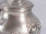 a silver teapot with a lid on a table