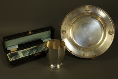 a silver plate and a silver cup next to a box