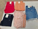cinq paires de jeans pour femmes posées sur une table