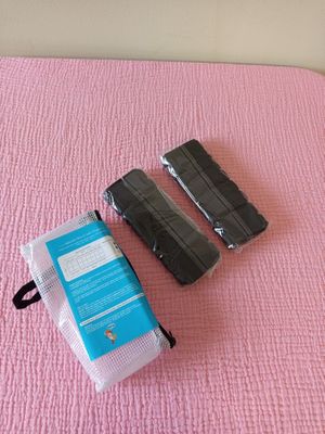 a pink blanket on the bed with a pair of luggage on it