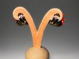 earrings in the shape of a letter v with red and black flowers
