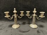 un ensemble de quatre chandeliers anciens en laiton avec des bougies