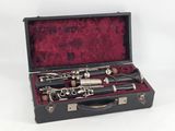 a black case with a silver and black clarinet in it