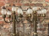 trois lampes de table anciennes en laiton et en verre posées sur une table en marbre