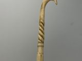 a close up of a cane with a curved handle on a table