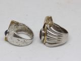 pair of silver rings with blue stones on them on a white surface