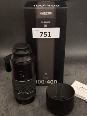 un objectif d'appareil photo et une tasse posés sur la table