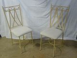 une paire de chaises en métal blanc avec des coussins rembourrés, devant un fond blanc
